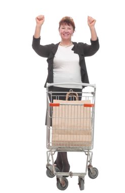 Beyaz arka planda izole edilmiş bir alışveriş arabasını iten bir kadının tam boy portresi.