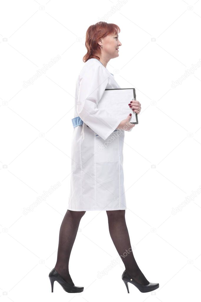 in full growth. competent female doctor with clipboard striding forward . isolated on a white background.