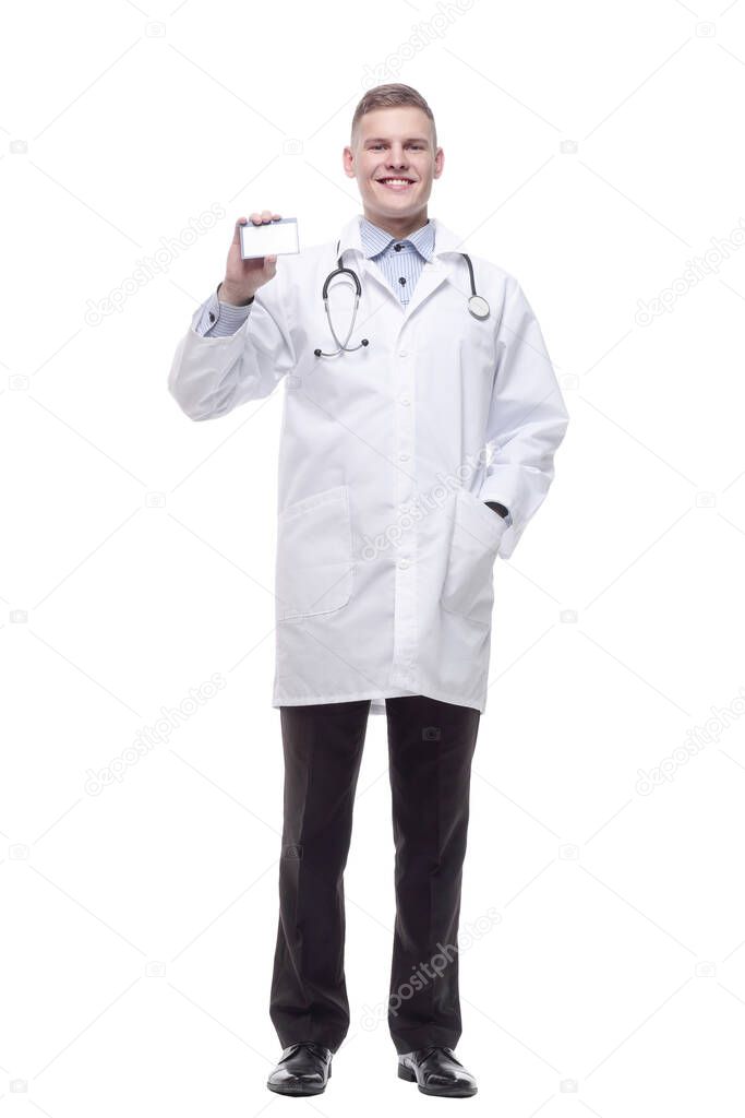 in full growth. smiling doctor showing his visiting card. isolated on a white background.