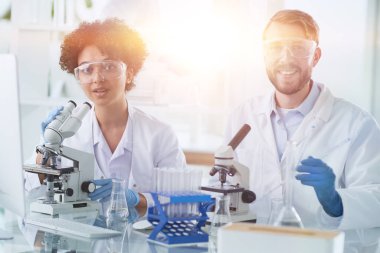 Bilim adamları laboratuarda birlikte gülümsüyor.