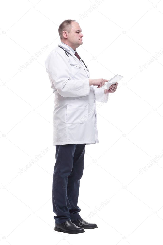 in full growth.a competent doctor with a digital tablet. isolated on a white background.