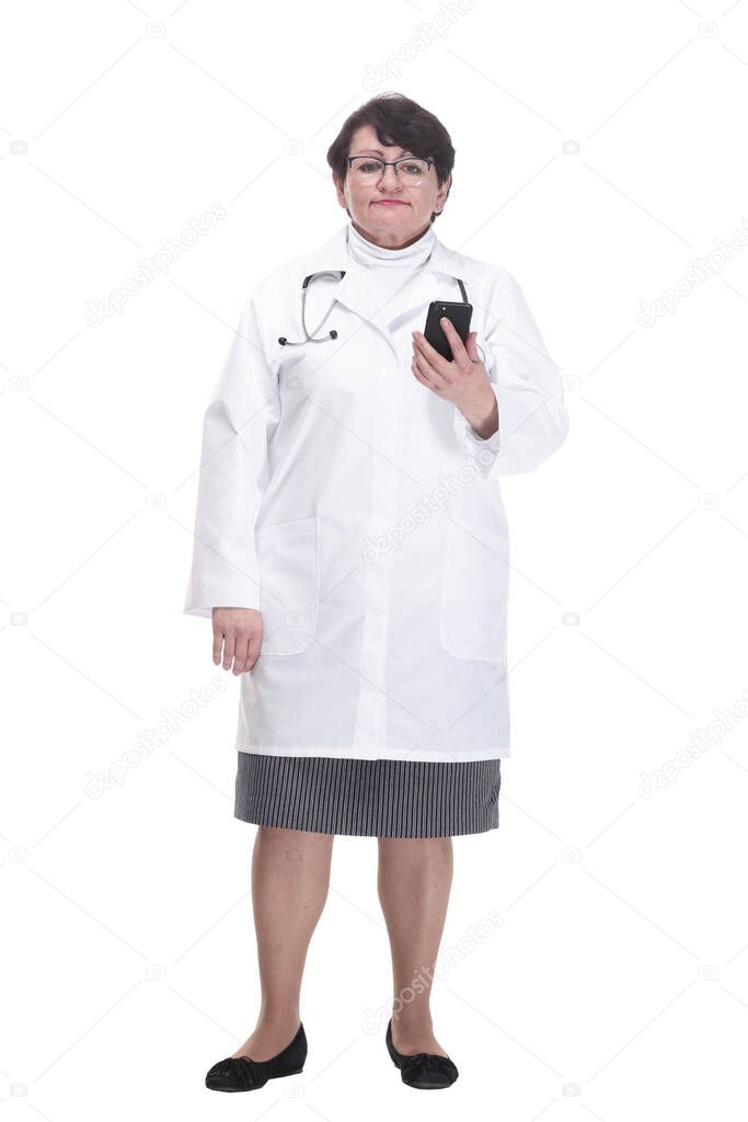 in full growth. senior female medic with a smartphone. isolated on a white background.