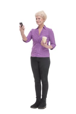 Tam gelişim. Akıllı telefonu ve kahvesi olan gülümseyen olgun bir kadın. beyaz arkaplanda izole edilmiş