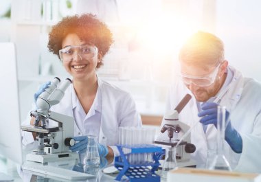 Bilim adamları laboratuarda birlikte gülümsüyor.