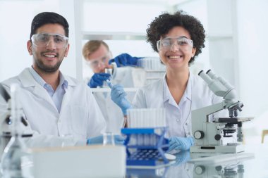Bilim adamları laboratuarda birlikte gülümsüyor.