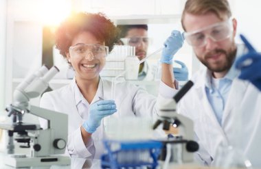 Bilim adamları laboratuarda birlikte gülümsüyor.