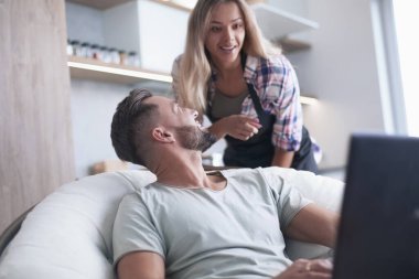 Kapat. Genç evli çift dizüstü bilgisayara bakıyor.