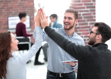 Mutlu iş adamlarının bir tablet tuttuğu ve beşlik çaktığı fotoğraf..