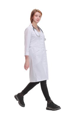Kameraya doğru yürüyen kadın doktor beyaz bir arka planda izole bir şekilde gülümsüyor.