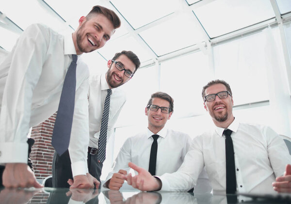 smiling business team near the desktop.the concept of teamwork