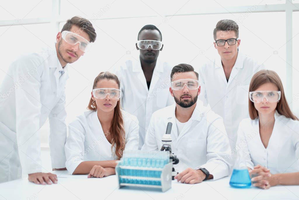 A group of biologists looking for a camera, a presentation of a group of scientists in the scientific research laboratory of scientific chemistry