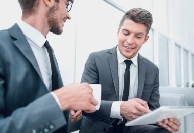 Ofiste bir kahve molası sırasında etkileşim ve tablet kullanma gülümseyen iş ortakları