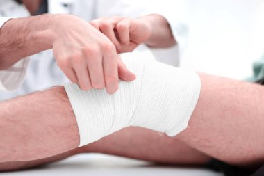 Doktor hospital.medical bakımda hastanın bacak sarmak orta bölümünde