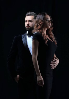 Yakışıklı genç erkek ve kadın kucaklama siyah elbiseli koyu arka plan üzerinde sakallı