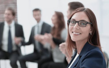 Arka planda meslektaşlarının güzel neşeli gülümseyen iş kadını yüzü