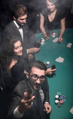 Bir grup zengin genç kumarhanede poker oynuyor. Fotokopi alanı ile fotoğraf.