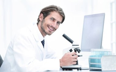 erkek bir bilimsel araştırmacı laboratuarda mikroskop kullanarak yan görünüm