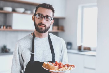 Çekici bir adamın elinde bir tabak sandviç. kopyalama alanı olan fotoğraf
