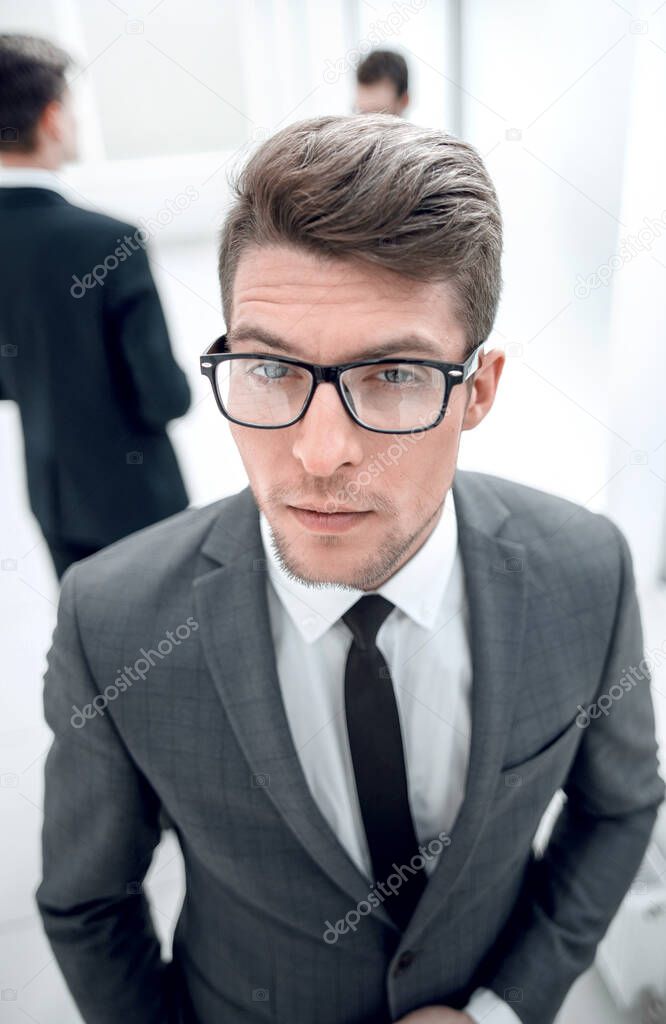 close up.confident young businessman on blurred office background.top view