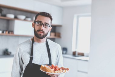 Çekici bir adamın elinde bir tabak sandviç. kopyalama alanı olan fotoğraf