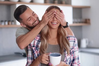 Kapat. Mutlu bir adam sabah mutfakta kız arkadaşıyla şakalaşıyor.