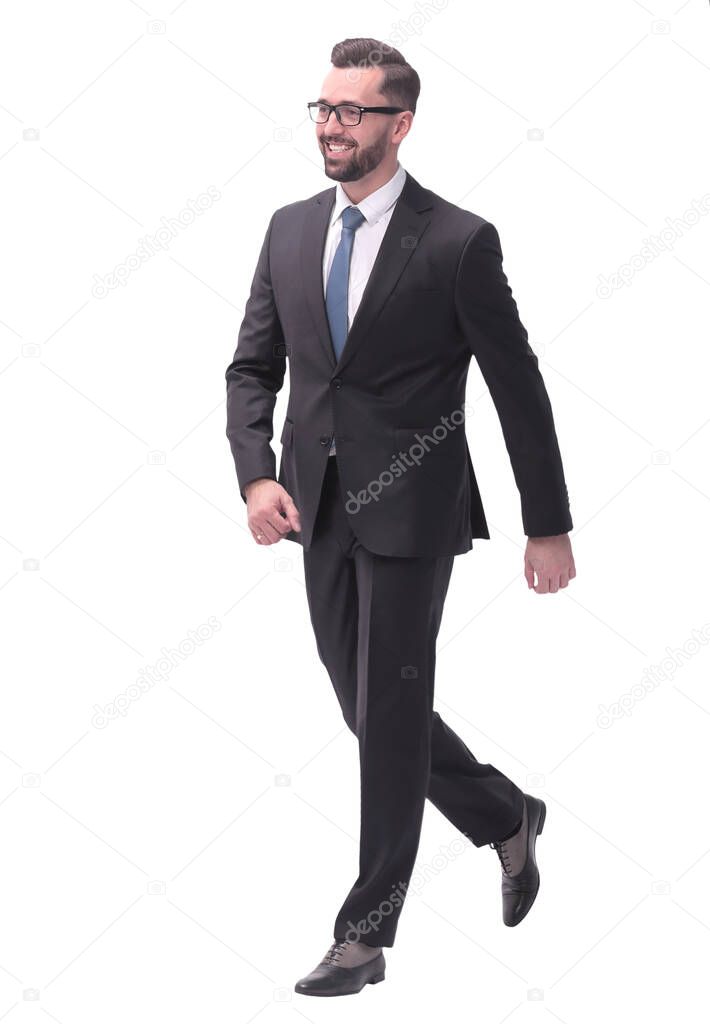 full length . confident young businessman moving forward. isolated on white background