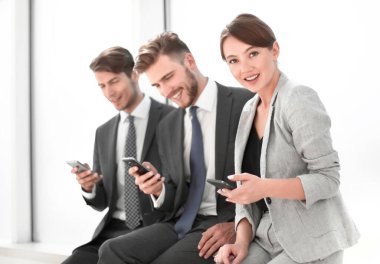 Akıllı telefonlarını kullanan gülümseyen çalışanlar. İnsanlar ve teknoloji.