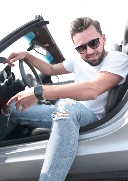 close up.stylish young man sitting in a luxury car .side view