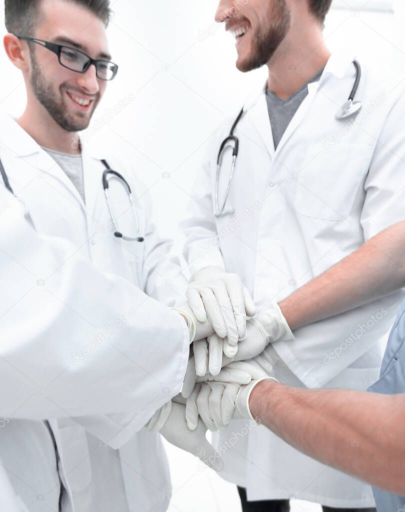 group of doctors,clasped their hands together.the concept of teamwork