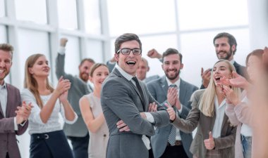 Şirket çalışanlarından oluşan bir grup zaferden dolayı birbirlerini tebrik ediyorlar. Takım çalışması kavramı