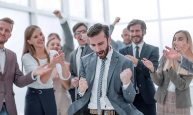 yakın kapatın. iş ekibi onların sevinçli lideri alkışlıyor. başarı kavramı