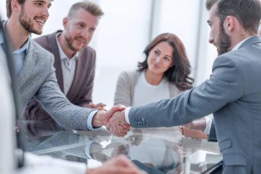 gülümseyen iş adamları bir toplantıda el sıkışıyor. işbirliği kavramı