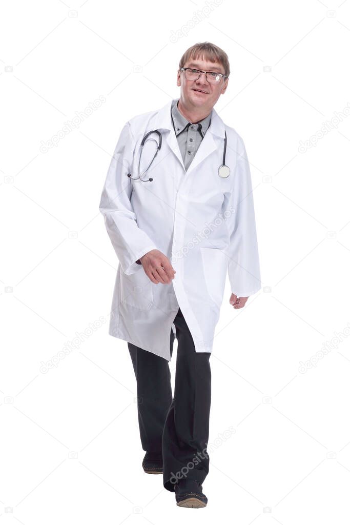 in full growth. friendly doctor with a stethoscope striding forward .isolated on a white background.