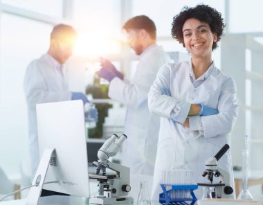 Bilim adamları laboratuarda birlikte gülümsüyor.