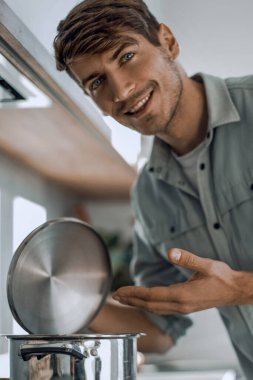 yakın yukarı. mutfak soba yakın ayakta mutlu genç adam
