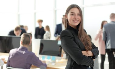Ofisin arka planında kendine güvenen genç bir iş kadını var. kopyalama alanı olan fotoğraf