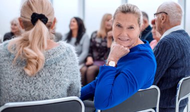 Olgun bayan kameraya bakıyor.