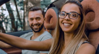 Cabrio bir arabanın direksiyonuna oturan modern genç kadın. birlikte seyahat