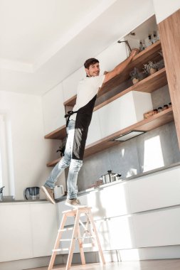ev mutfağında bir merdiven üzerinde ayakta adam. kopya alanı ile fotoğraf
