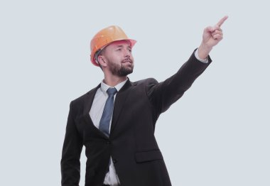 Tam gelişim. Miğferli genç işadamı kopyalama alanını işaret ediyor. beyaz üzerine izole