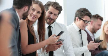 Şirketin genç çalışanları akıllı telefonlarının ekranlarına bakıyor. İnsanlar ve teknoloji