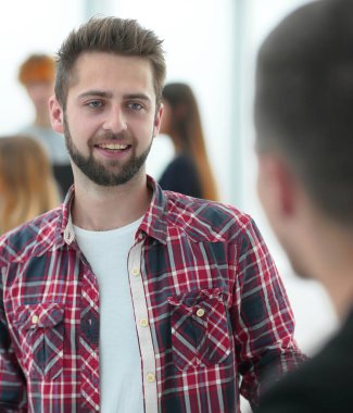 Kapat. Meslektaşları arasında duran genç bir çalışan. ofis çalışma günleri