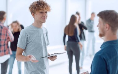 Dijital tabletli genç bir çalışan meslektaşıyla konuşuyor. ofis çalışma günleri