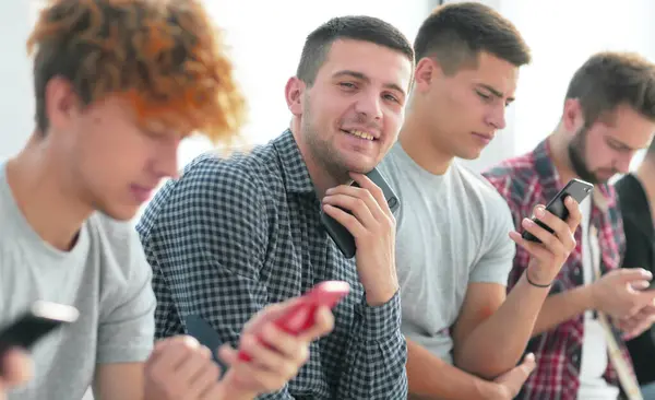 Cerca Grupo Jóvenes Con Smartphones Sentados Una Fila —  Fotos de Stock