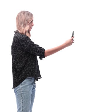 Yan görünüş. Akıllı telefonunun ekranına bakan çekici genç bir kadın. beyaz arkaplanda izole.