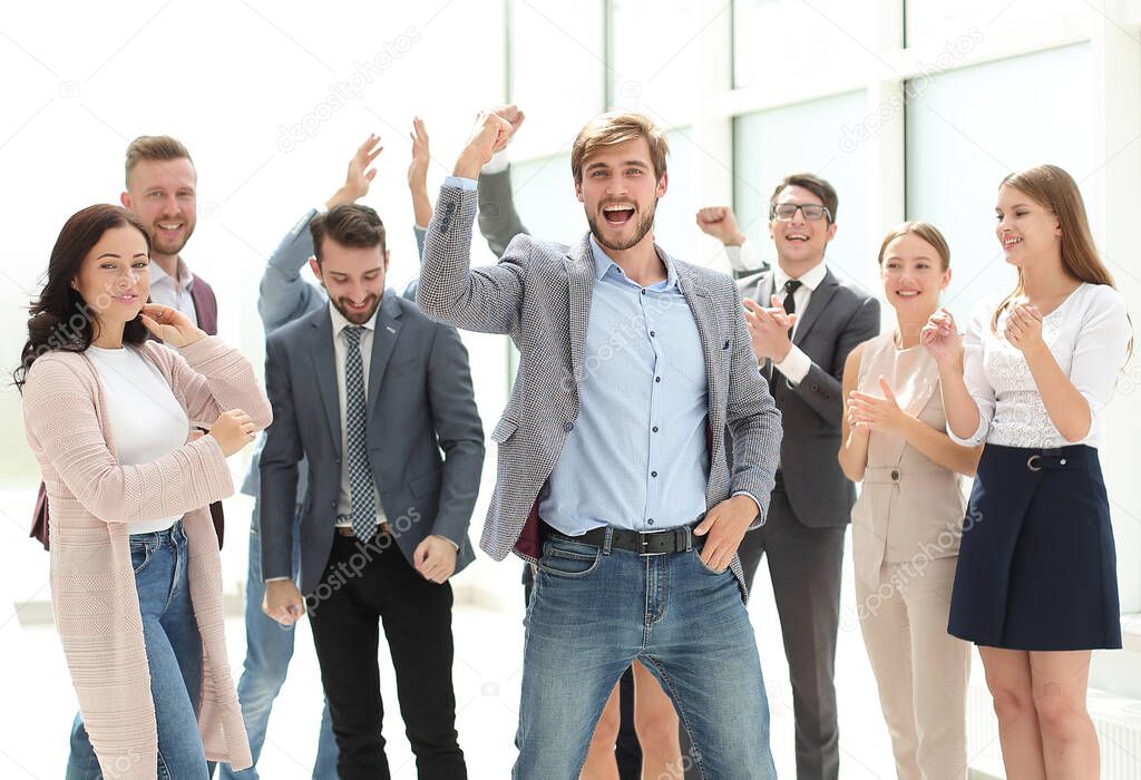 happy young businessman standing in front of his business team. success concept