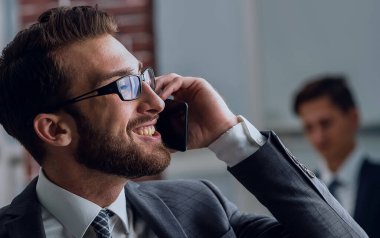 Heyecanlı işadamı cep telefonu konuşurken izliyor