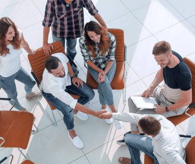 Yukarıdan görüntü.Kopya alanı olan bir masa.Fotoğrafın arkasındaki meslektaşlarla tokalaşma