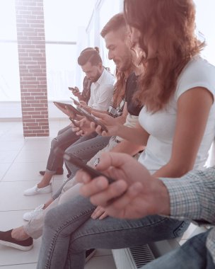 ofis lobisinde oturan bir taşınabilir aygıt kullanarak iş takım.