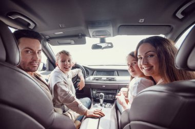 Arabada oturan neşeli bir aile. Aile tatili